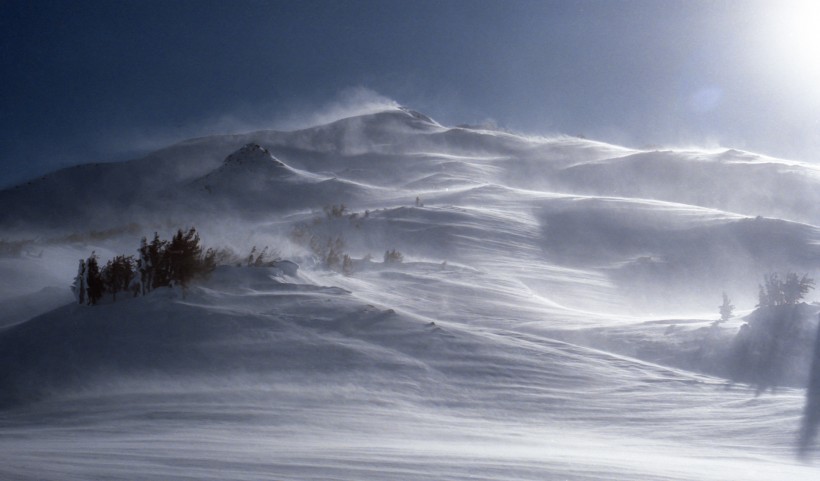 風中揚起白霧的雪山圖片