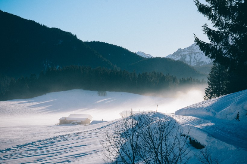 風中揚起白霧的雪山圖片