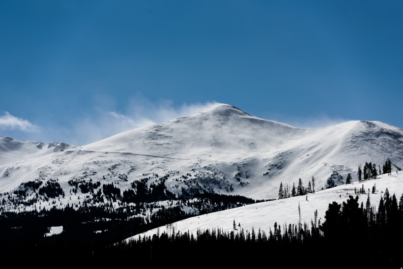 風中揚起白霧的雪山圖片