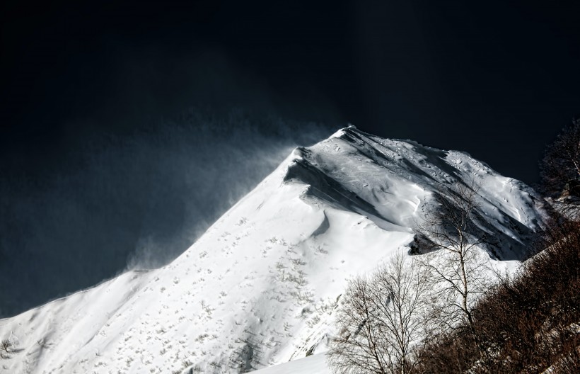 風中揚起白霧的雪山圖片