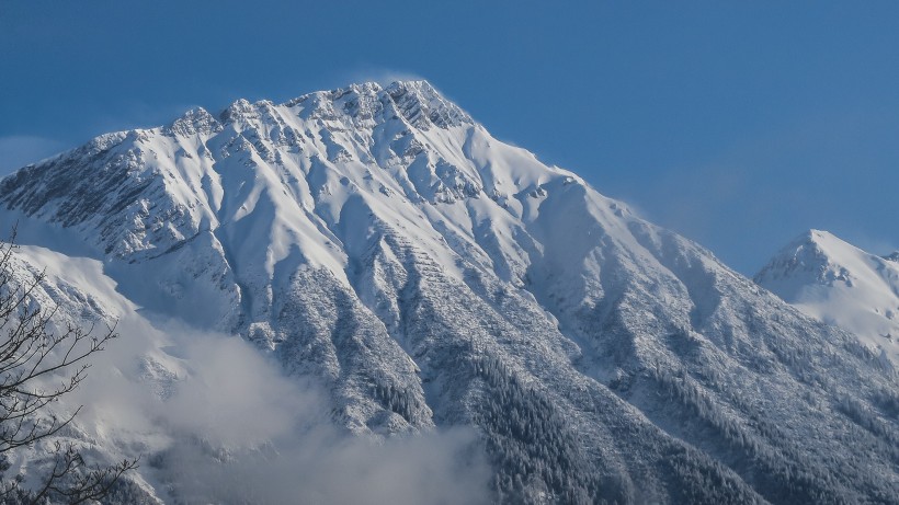 風中揚起白霧的雪山圖片