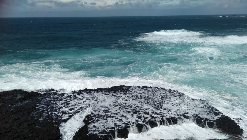 拍擊岸邊礁石的海浪圖片