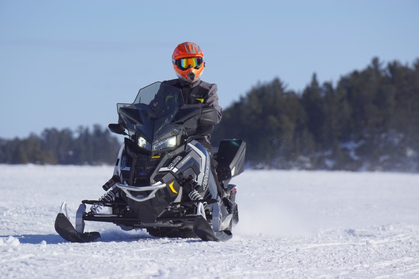 在雪山裡開着雪地車的人圖片