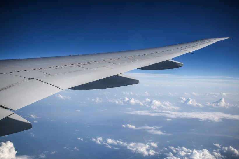 高空雲層上的飛機機翼圖片