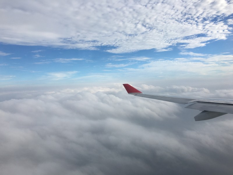 高空雲層上的飛機機翼圖片