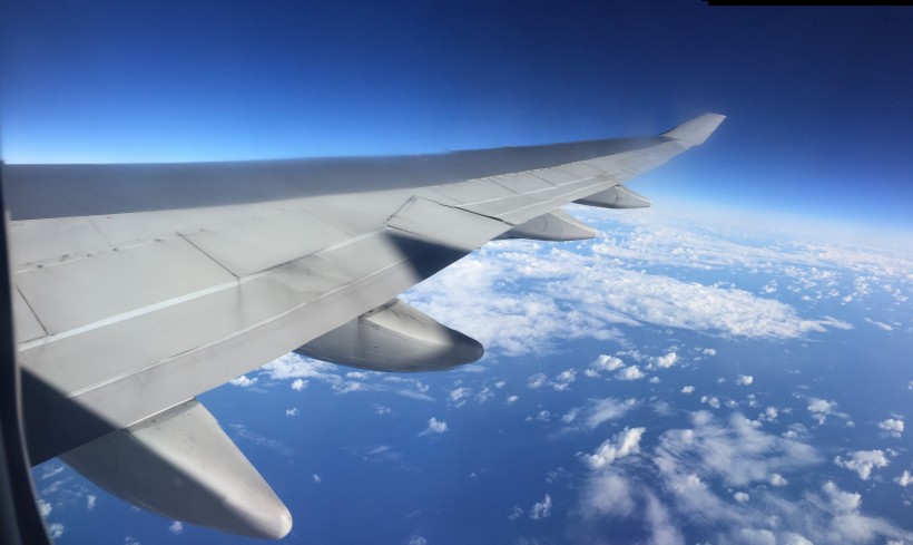 高空雲層上的飛機機翼圖片