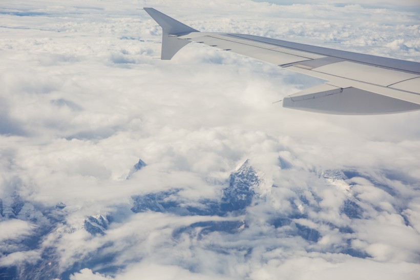 高空雲層上的飛機機翼圖片