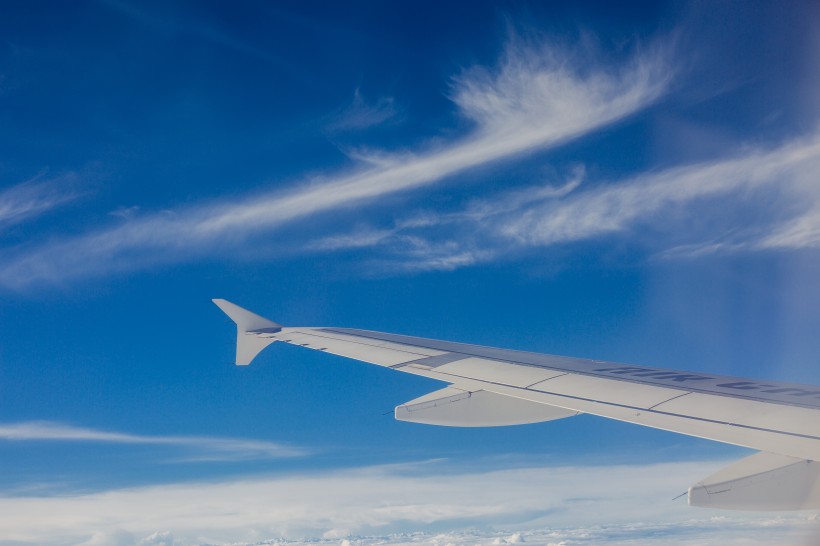 高空雲層上的飛機機翼圖片