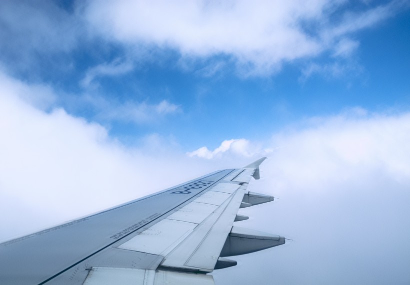 高空雲層上的飛機機翼圖片