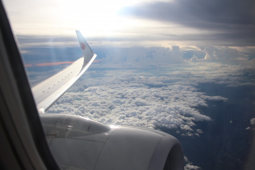 高空雲層上的飛機機翼圖片