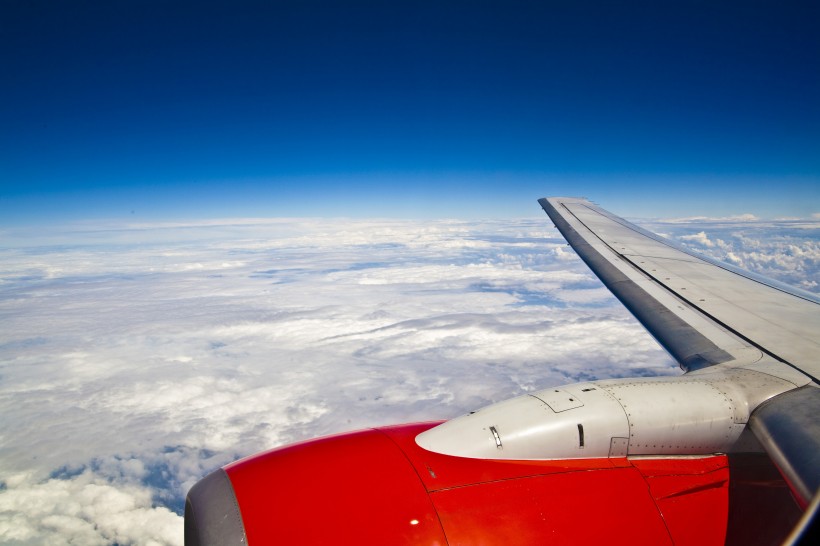 高空雲層上的飛機機翼圖片