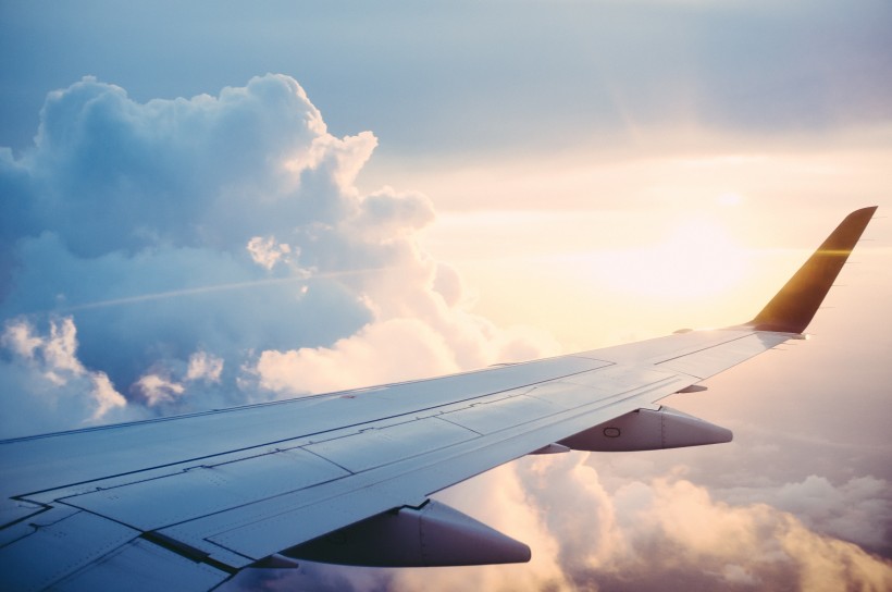 高空雲層上的飛機機翼圖片